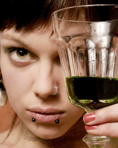 Woman_holding_up_glass_of_green_liquid