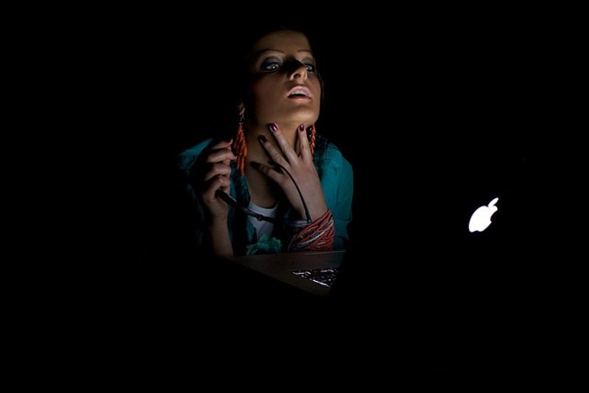 800px-Woman_in_a_dark_room_looking_to_a_mac_computer